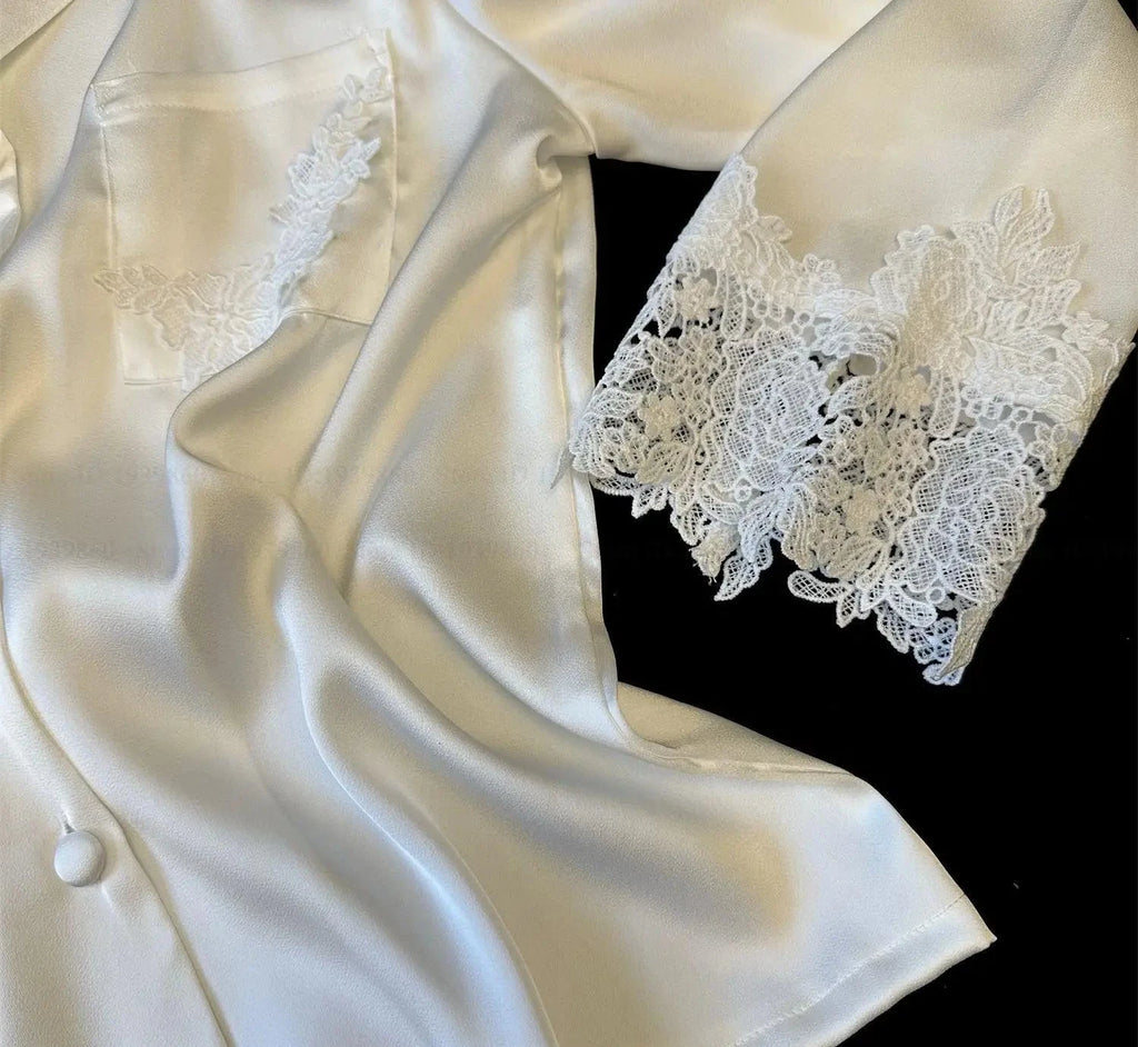 White satin robe with lace details on a black background