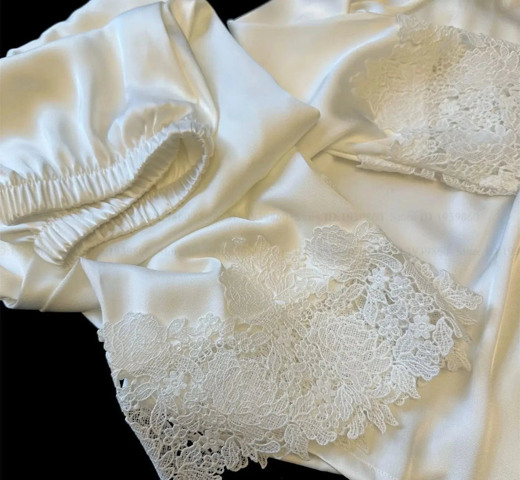 Close-up of white satin fabric with lace detailing on a black background