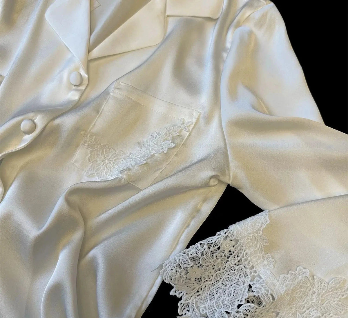 White satin robe with lace trim on a black background